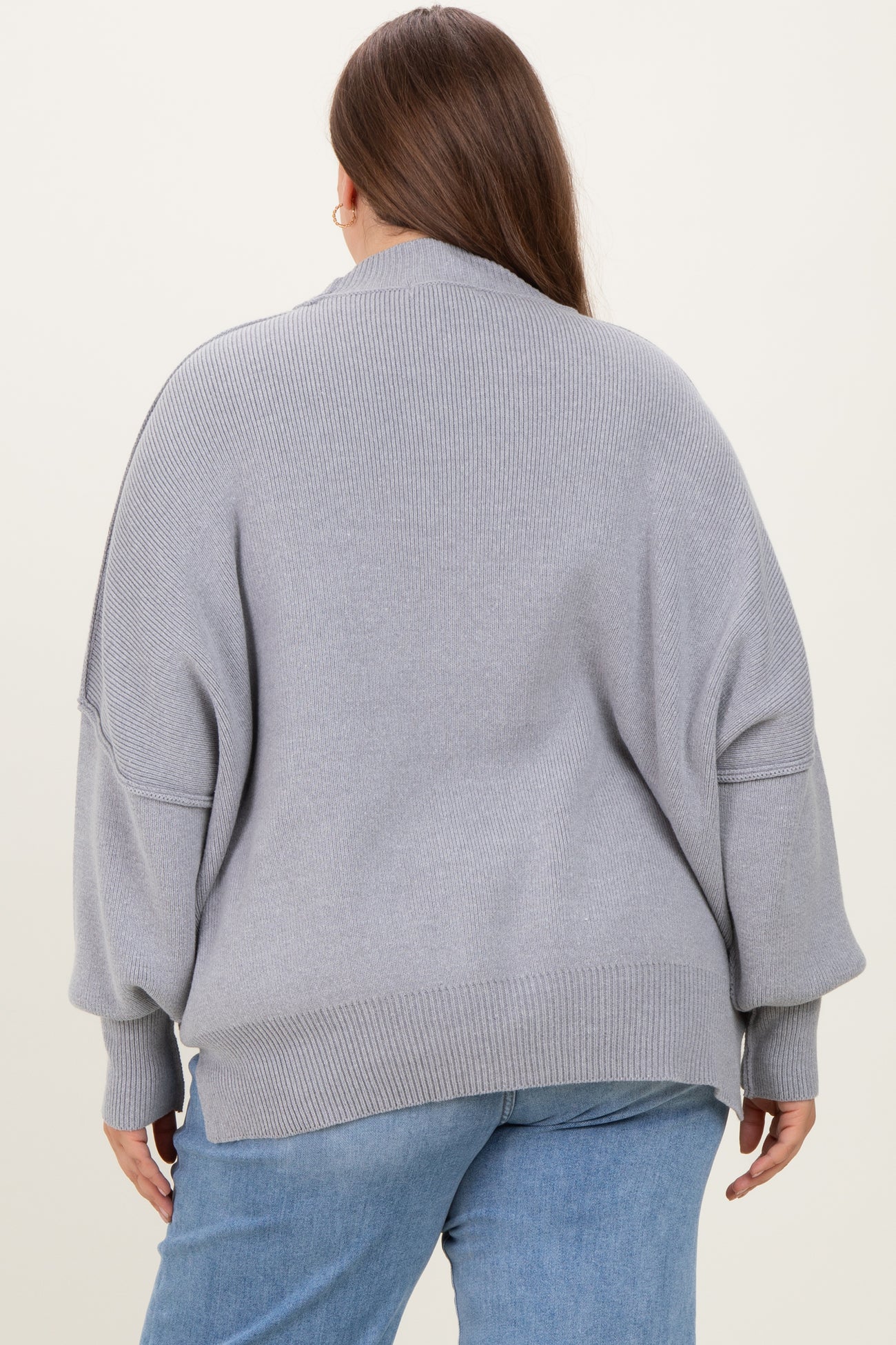 woman wearing a gray oversized maternity sweater with dropped shoulders and ribbed detailing, seen from the back