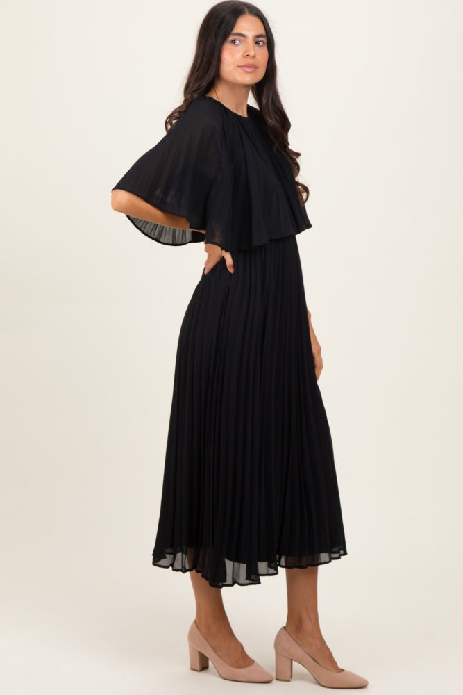 woman wearing a black pleated midi dress with a flutter sleeve and a flowy silhouette