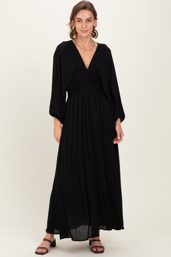 woman wearing a black maxi dress with a smocked bodice and long sleeves
