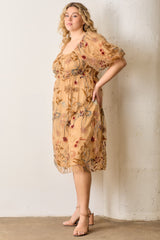 woman wearing a floral embroidered plus size dress with puff sleeves and a square neckline, standing against a wall