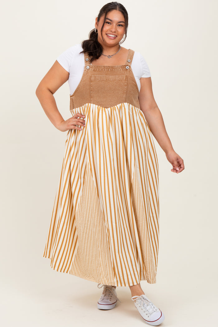 woman wearing a plus size striped maxi dress with a tan and white color scheme and denim-style top portion