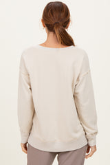 woman wearing a beige oversized sweatshirt with a relaxed fit, seen from the back