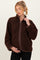 woman wearing a brown maternity fleece jacket with a quarter zip, holding her baby bump