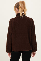 woman wearing a dark brown maternity pullover jacket with a cozy fleece texture and a high collar, seen from the back