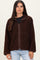 woman wearing a chocolate brown fuzzy zip-up jacket over a black top and light blue jeans