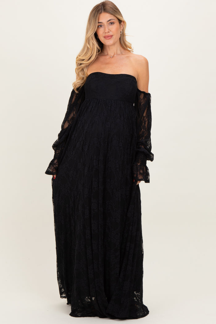 woman wearing a black lace strapless maternity gown with flowing sleeves and a visible baby bump
