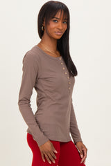 woman wearing a taupe ribbed long sleeve henley top with buttons and slim fit, paired with red leggings