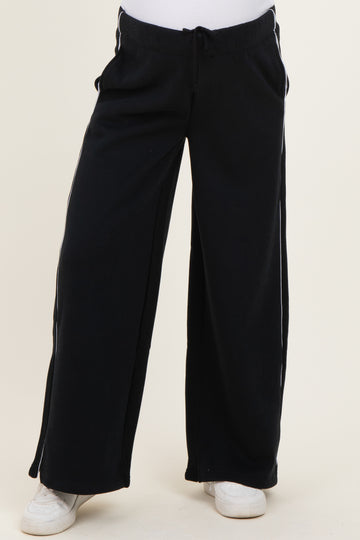 maternity wear in black wide-leg sweatpants with side pockets and elastic waistband, modeled by a pregnant woman