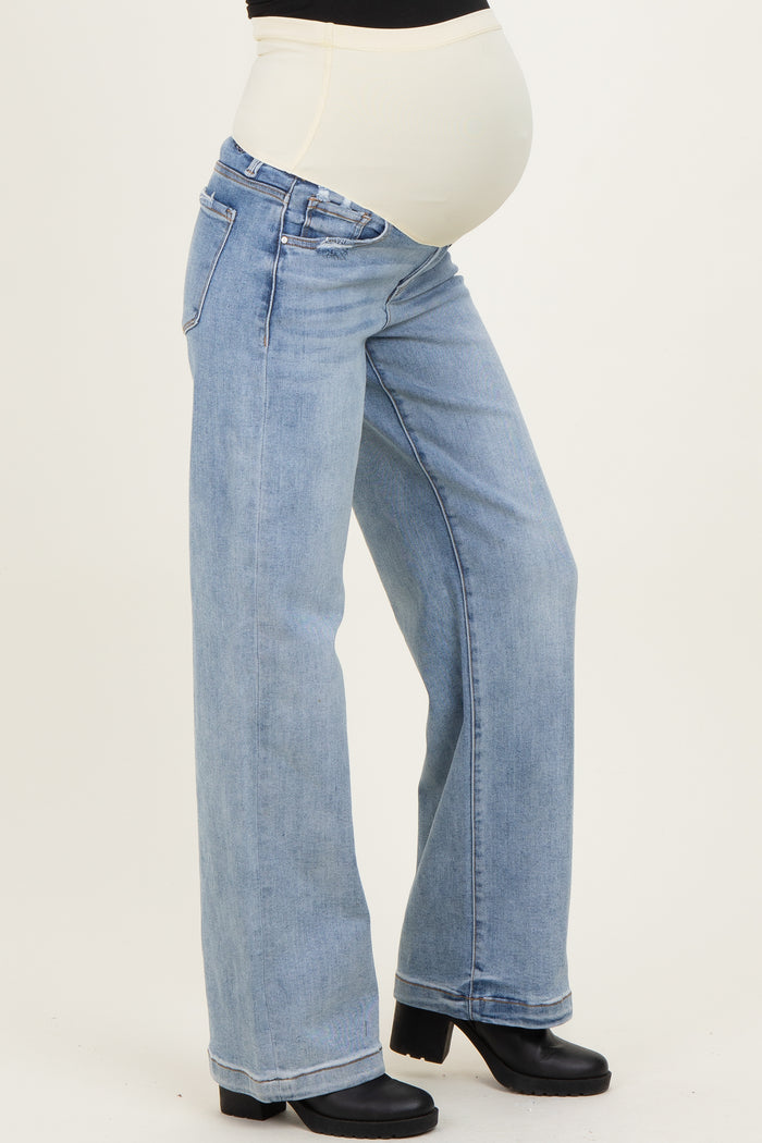 woman wearing a pair of light blue wide leg maternity jeans with a supportive belly band and visible baby bump