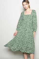 woman wearing a green floral maxi dress with a square neckline and long sleeves