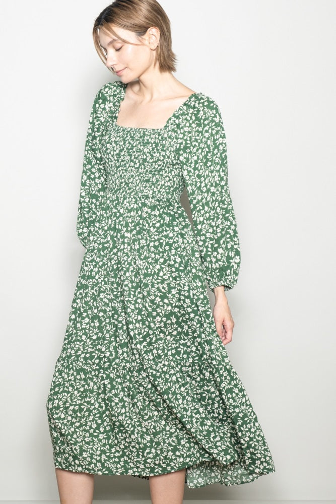 woman wearing a green floral long sleeve midi dress with a square neckline and relaxed fit