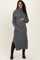 woman wearing a grey turtleneck maternity sweater dress with side slits and cradling her baby bump