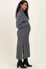 woman wearing a grey turtleneck maternity dress with side slits and a visible baby bump