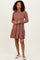 woman wearing a brown striped long sleeve dress with a tiered skirt and white slip-on shoes