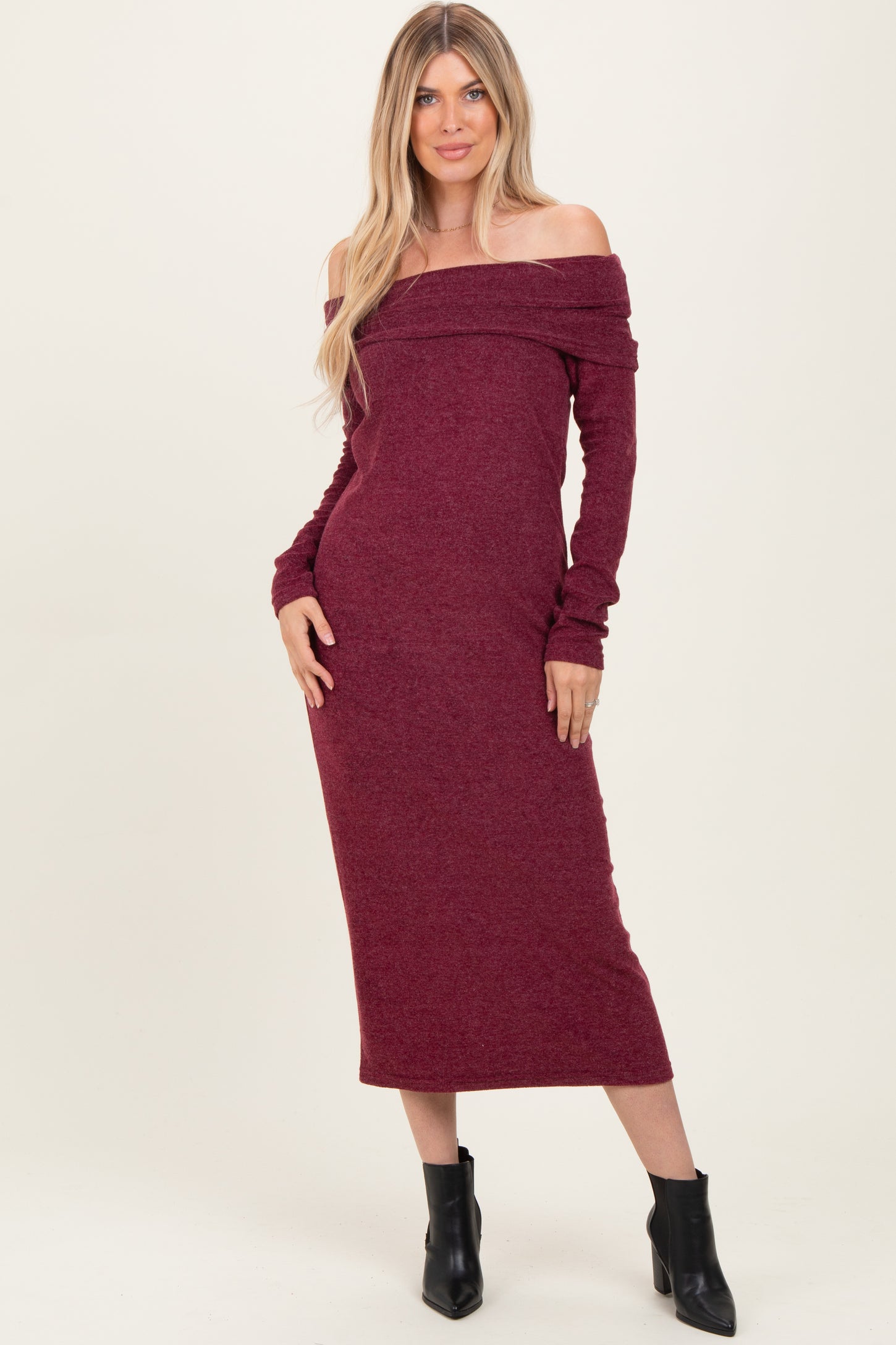 woman wearing a burgundy off-the-shoulder long sleeve dress with fitted silhouette and ribbed fabric