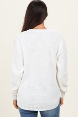 woman wearing a white waffle knit sweater with long sleeves and a relaxed fit, viewed from the back