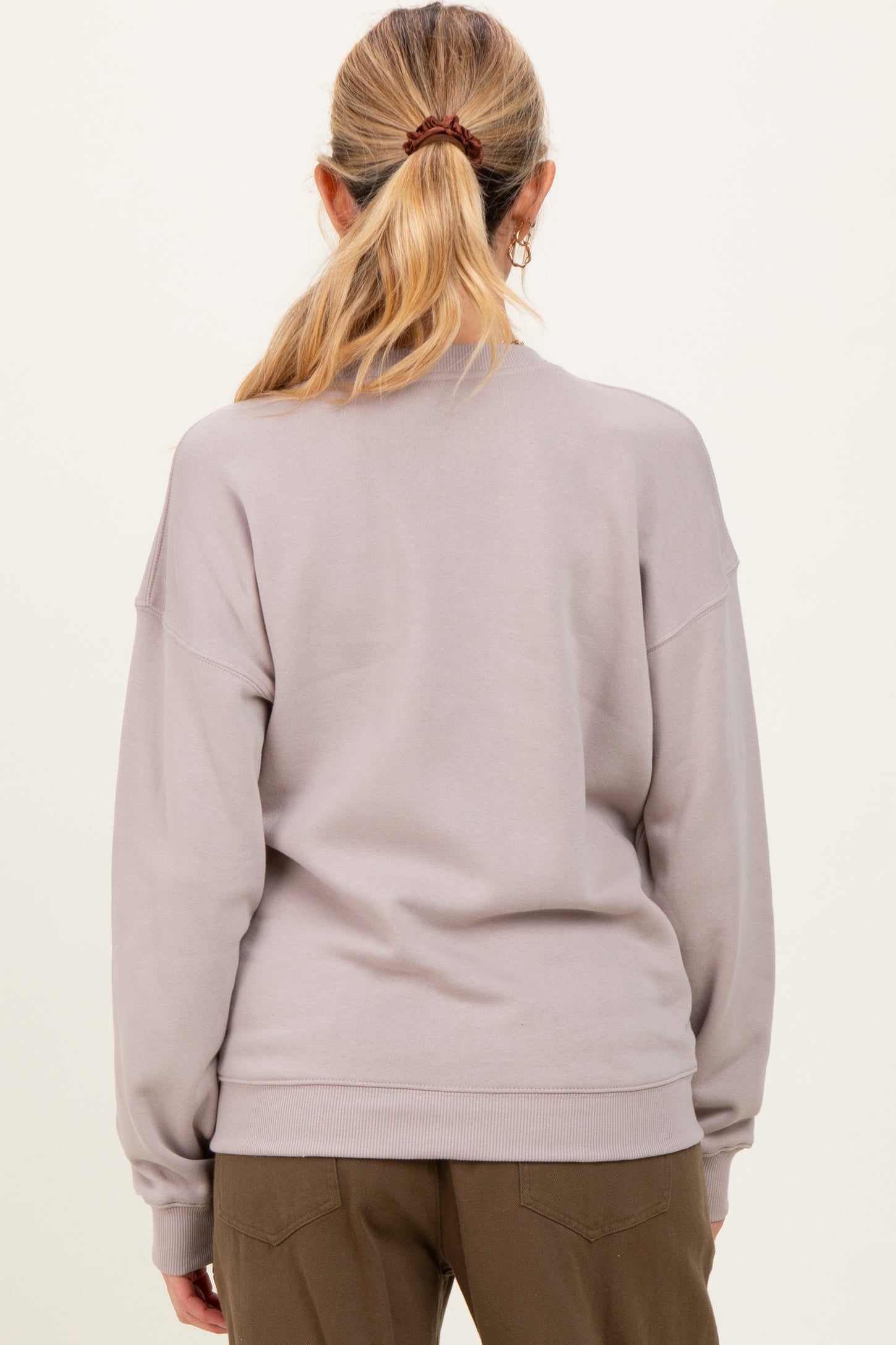 woman wearing a light gray maternity sweatshirt from the back with a relaxed fit and drop shoulder details