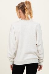 woman wearing a light gray oversized maternity sweatshirt, shown from the back, with loose sleeves and a relaxed fit