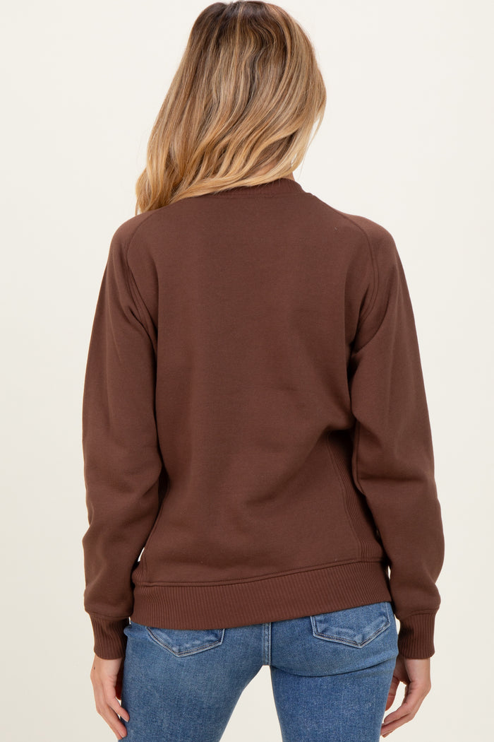 woman wearing a brown maternity sweatshirt, showing the back view with fitted sleeves and ribbed hem