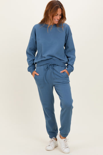 woman wearing a blue matching sweatshirt and jogger set with pockets and elastic cuffs