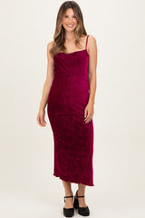 woman wearing a burgundy maternity maxi dress with spaghetti straps and a fitted silhouette