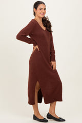 woman wearing a brown v-neck long sleeve maxi sweater dress with side slits and black flats