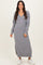 woman wearing a gray long sleeve knit maxi dress with a V-neck and side slits, styled with white sneakers