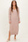 woman wearing a light pink knitted long sleeve v-neck dress with ribbed details and a relaxed fit