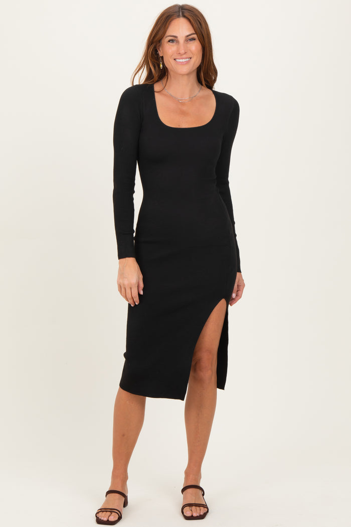 woman wearing a black ribbed long sleeve midi dress with a side slit and strappy heels