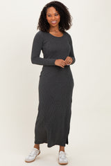 woman wearing a black ribbed long sleeve maxi dress with a round neckline and side slits, paired with white sneakers