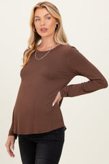 woman wearing a brown long sleeve maternity top with a visible baby bump