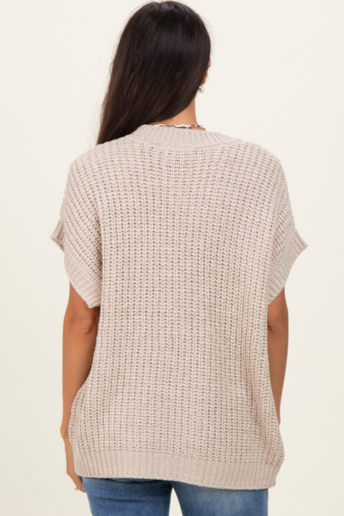 woman wearing a beige knitted oversized sweater from the back, paired with blue jeans