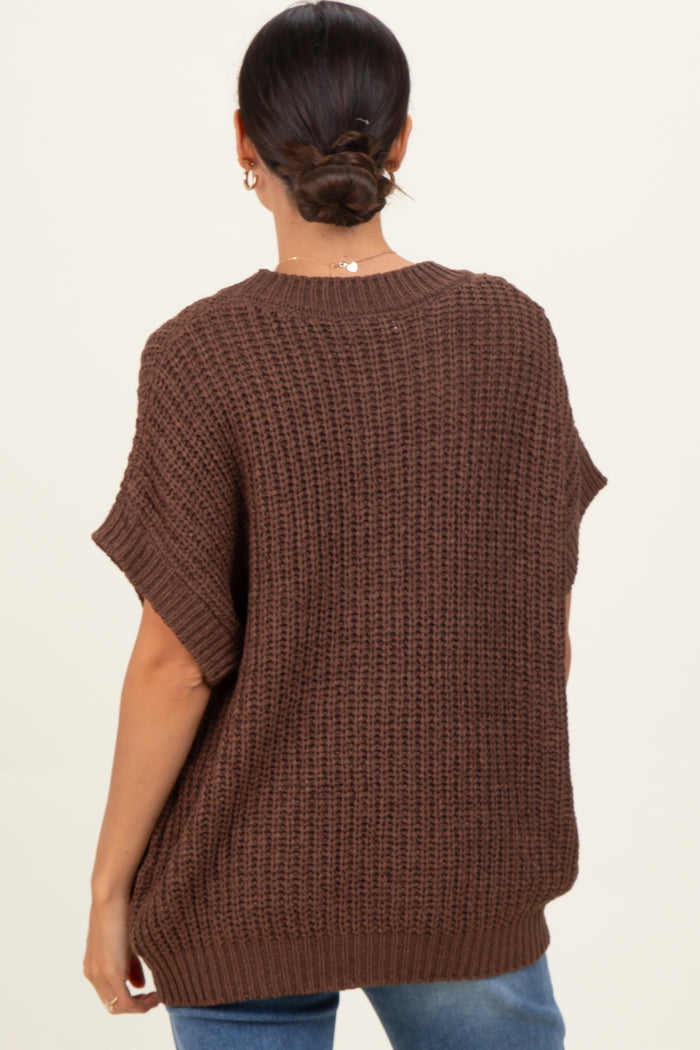 woman wearing a brown oversized knit sweater with short sleeves, viewed from the back