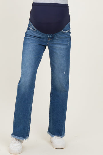 woman wearing maternity distressed straight leg jeans with a dark blue over-the-bump waistband and white sneakers