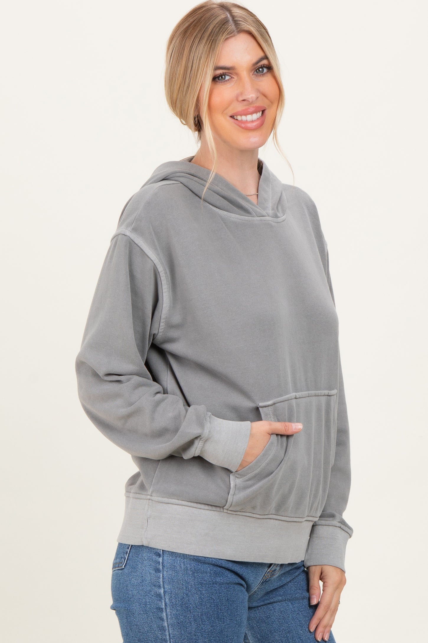 woman wearing a gray oversized hoodie with a front pocket and a relaxed fit