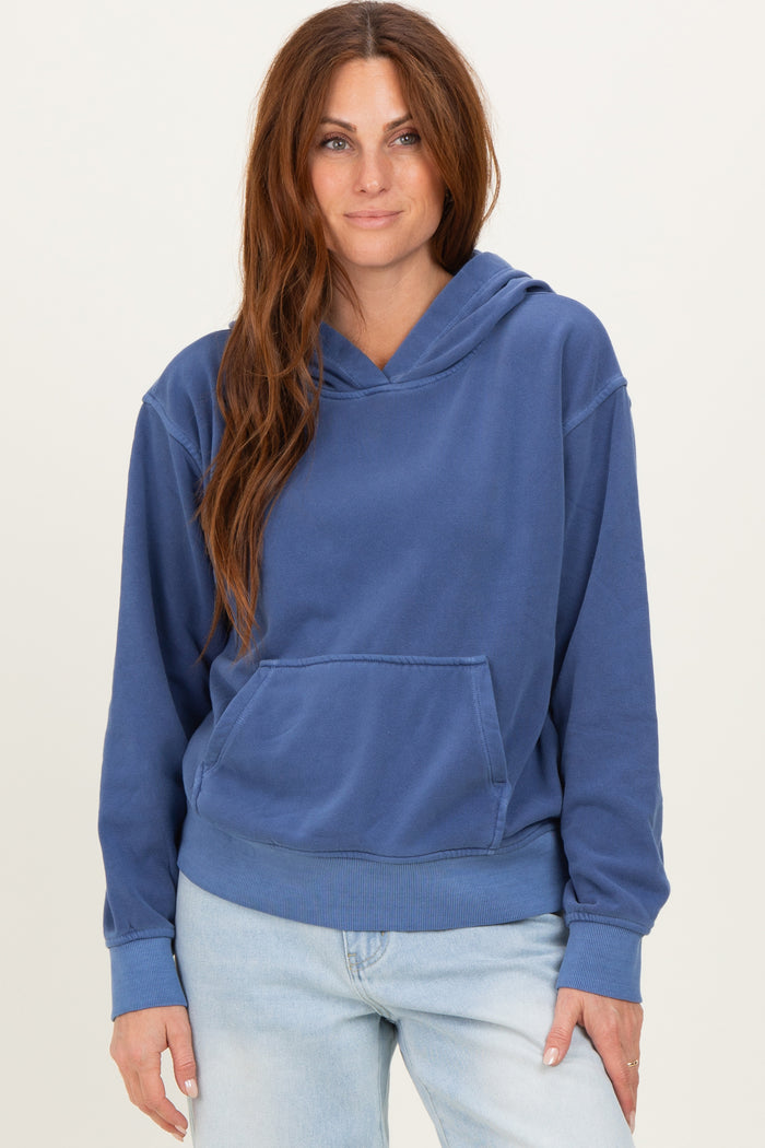 woman wearing a blue oversized hoodie with a front pocket and a relaxed fit, paired with light denim jeans