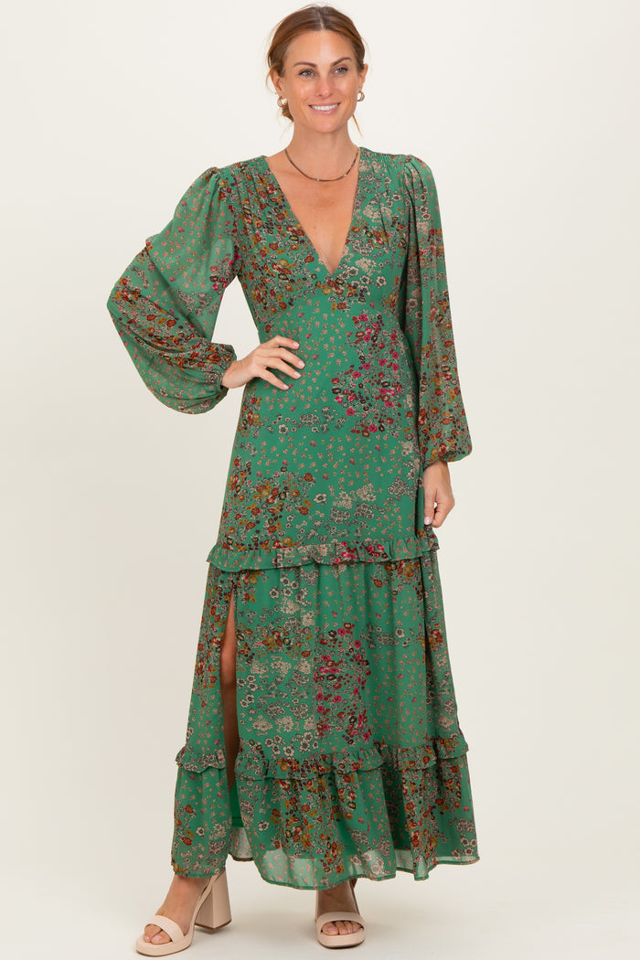 woman wearing a green floral maxi dress with long sleeves, deep v-neck, and tiered ruffles