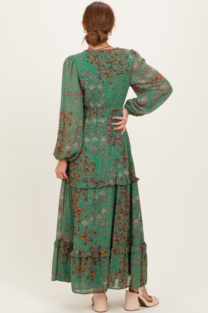 woman wearing a green floral maxi dress with long sleeves and tiered ruffles, showing the back view