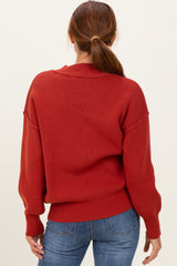 woman wearing a cozy red oversized sweater with long sleeves, styled with a relaxed fit and ribbed details