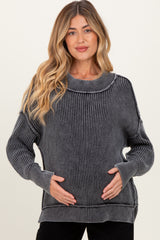 woman wearing a black and gray striped maternity sweater and holding her baby bump