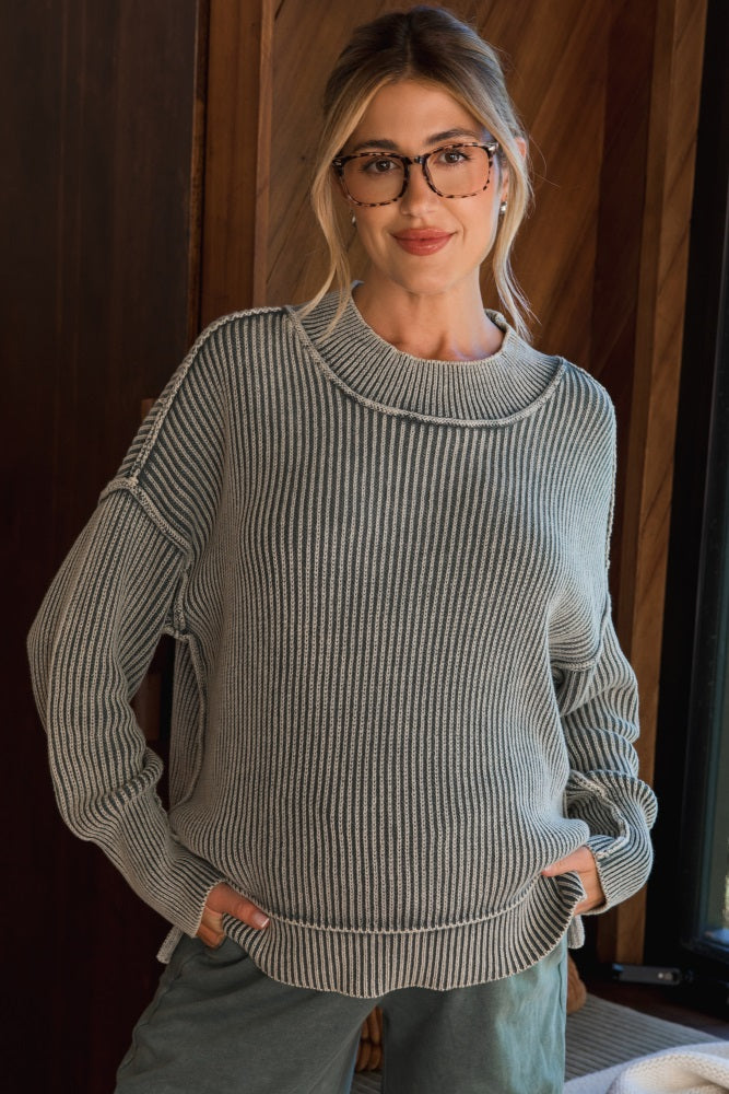 woman wearing a gray and white striped maternity sweater with a relaxed fit and a high neckline
