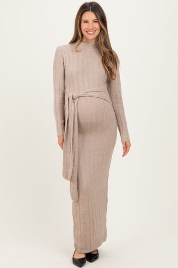 woman wearing a beige long sleeve ribbed maternity dress with a tie at the waist and a visible baby bump
