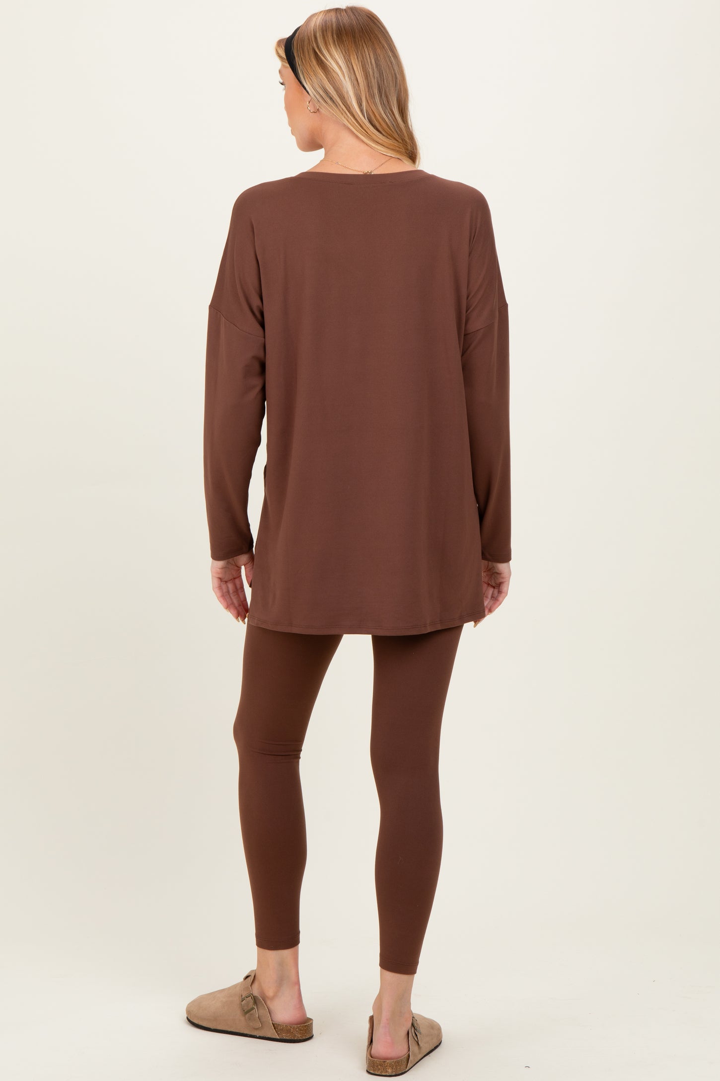 woman wearing a brown maternity long sleeve tunic and matching leggings, styled with casual slip-on shoes