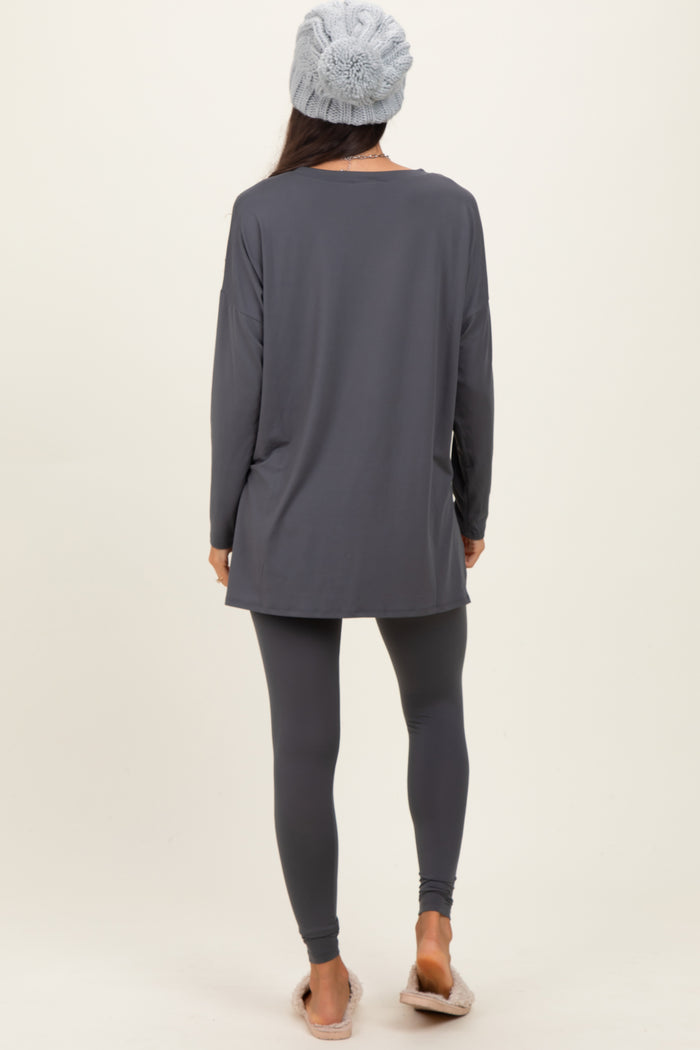 woman wearing a gray long sleeve top and matching leggings with a knit beanie and cozy slippers, viewed from the back