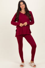 woman wearing a burgundy long sleeve top and matching leggings, paired with cozy slippers