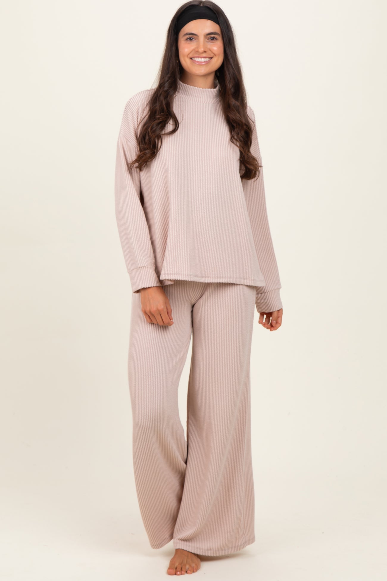 woman wearing a light beige ribbed long sleeve top and matching wide-leg pants