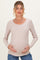 woman wearing a light beige long sleeve maternity top and holding her baby bump