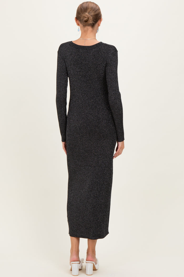 woman wearing a black long sleeve ribbed maternity dress, showing a sleek back view and floor-length style