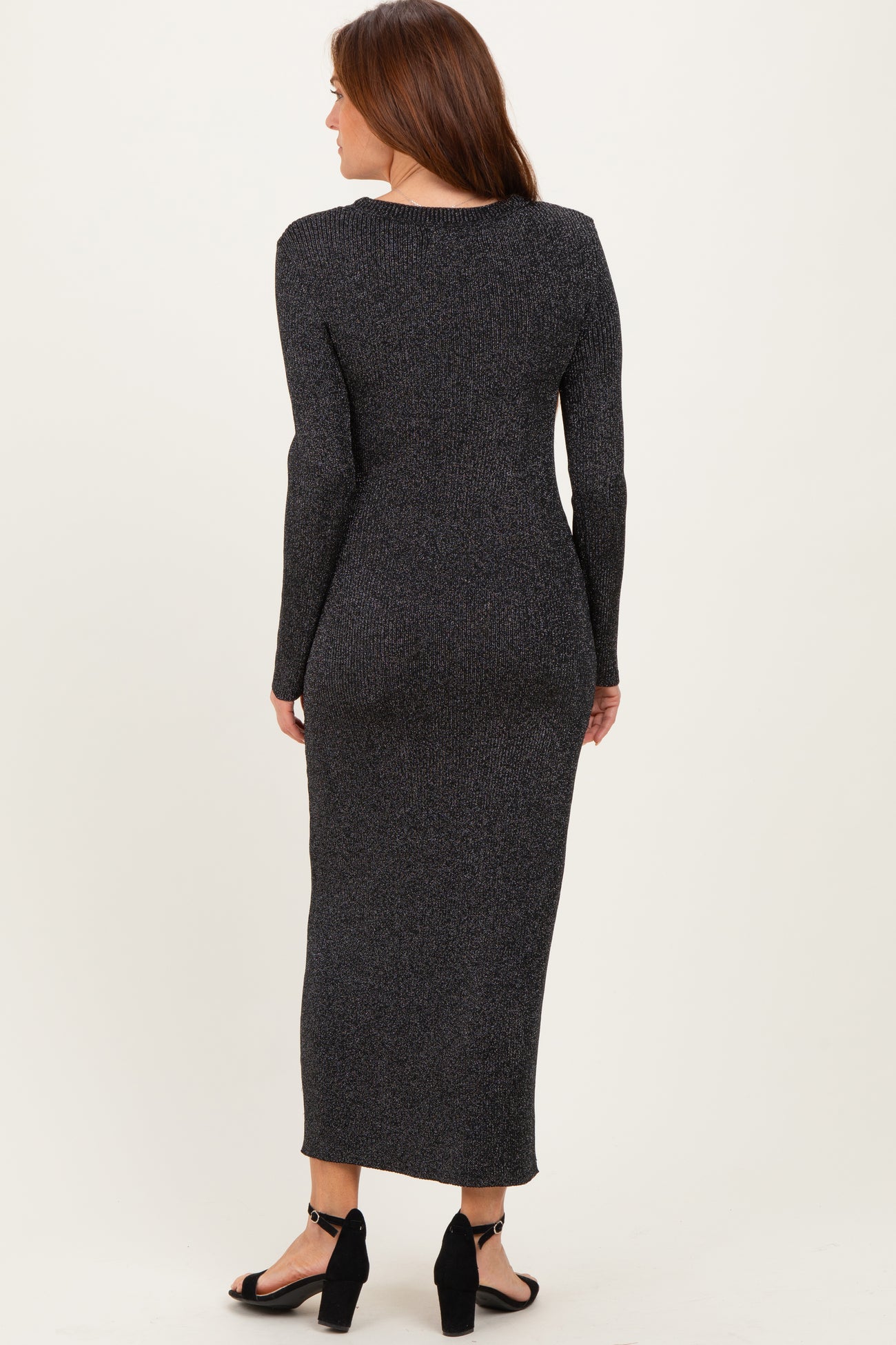 woman wearing a black sparkly long sleeve maxi dress with a fitted silhouette and back view