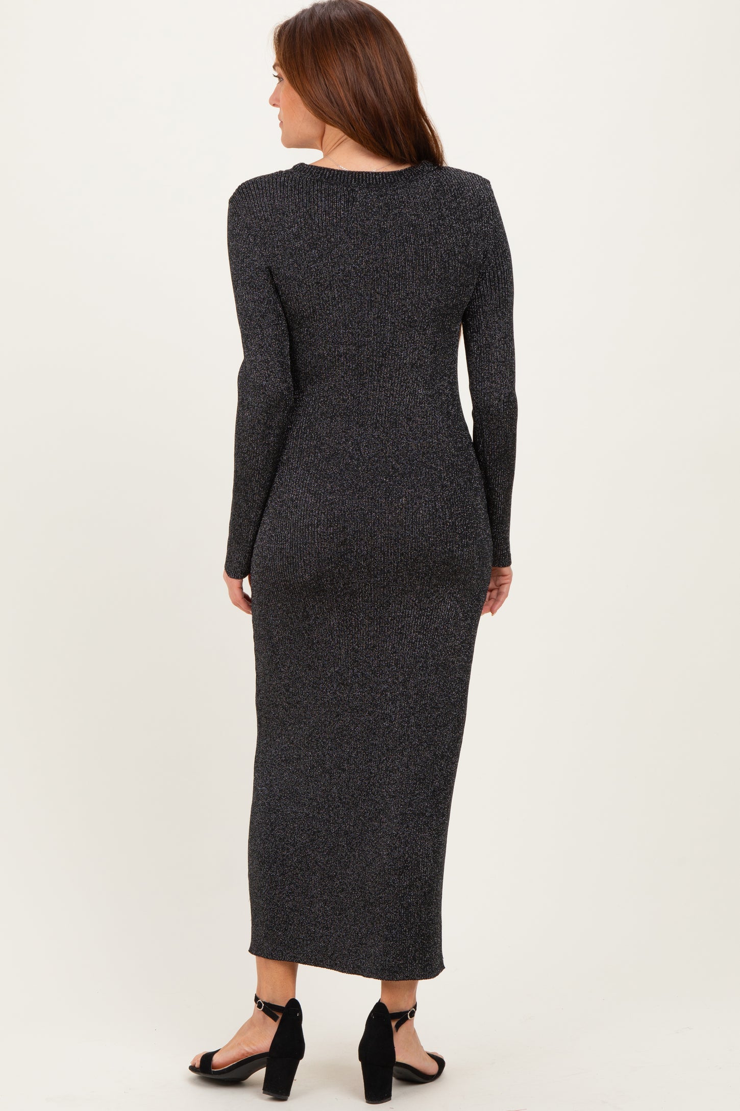 woman wearing a black sparkly long sleeve maxi dress with a fitted silhouette and back view
